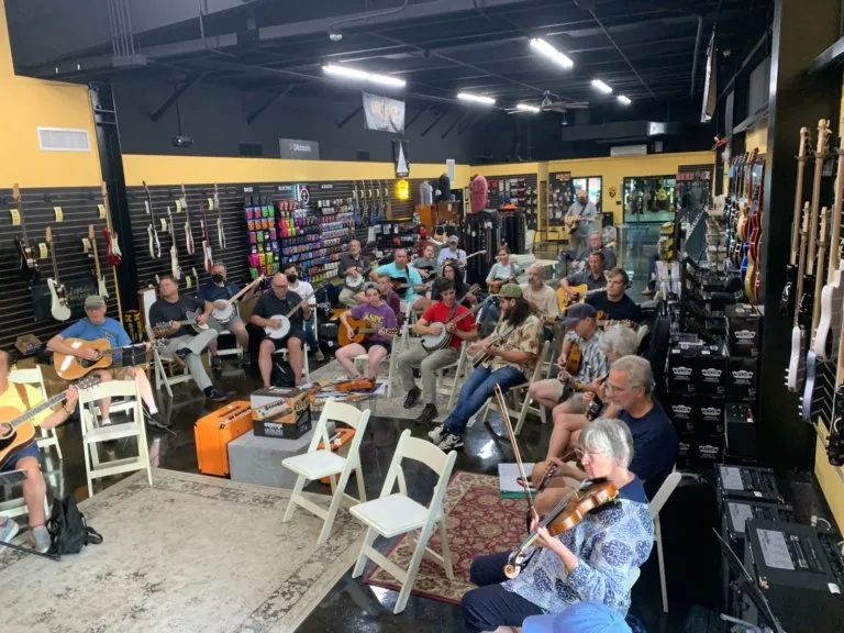 Musicians at a PineCone beginners bluegrass jam at Harry’s Guitar Shop