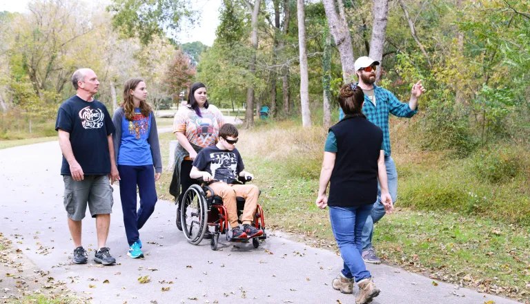 group of adults walking and one in a wheelchair